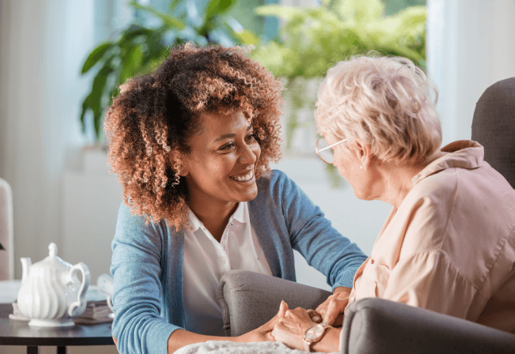 carer smiling at older woman in a care home