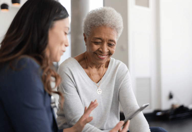older woman being shown something on a phone
