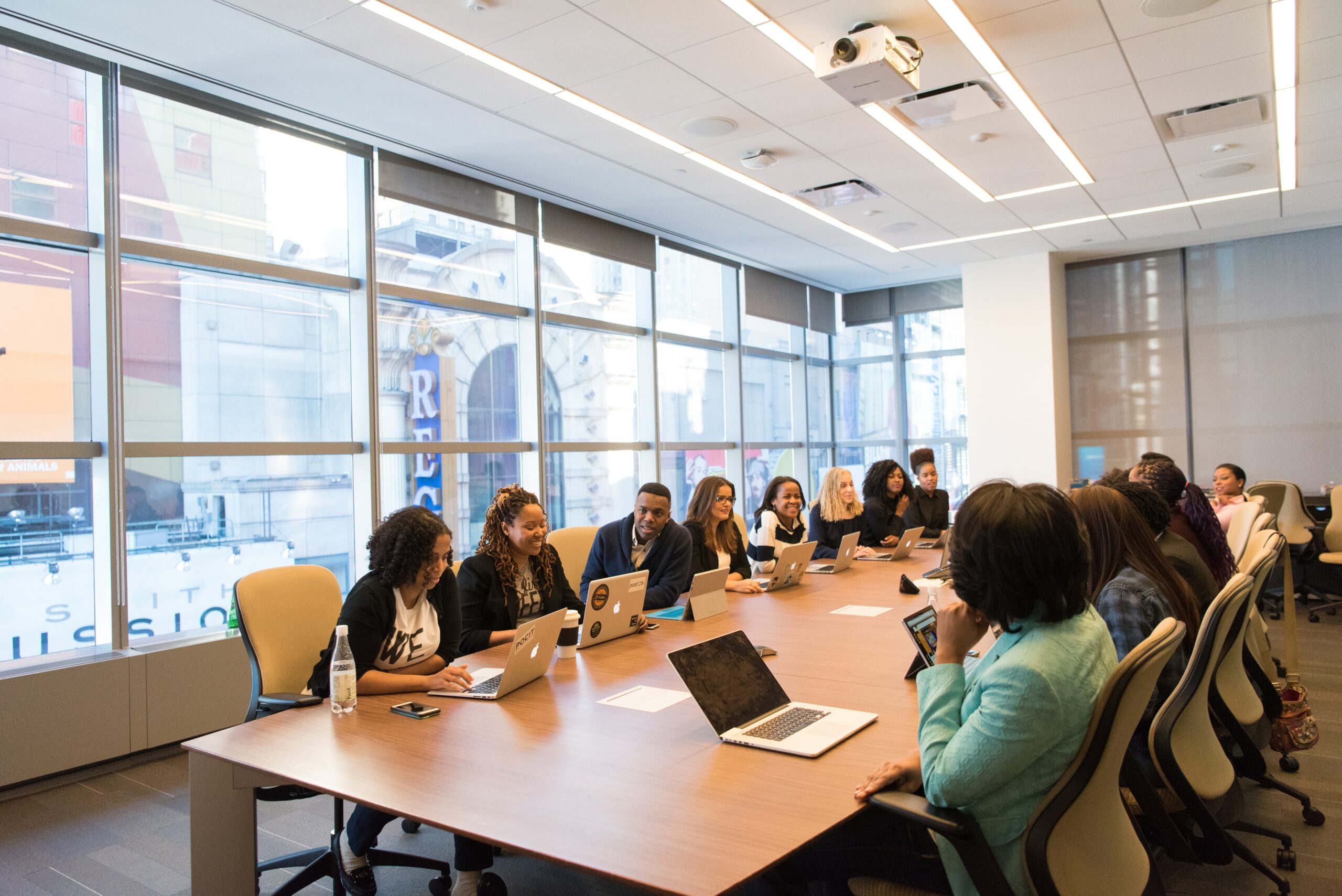 team meeting in a conference room using macbooks